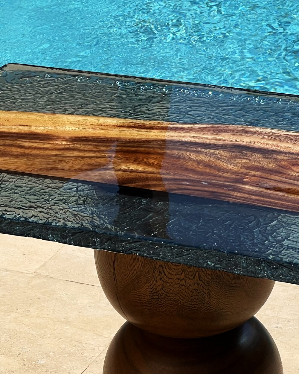 Strata — the live-edge wood spine reading clean through the rippled turquoise resin