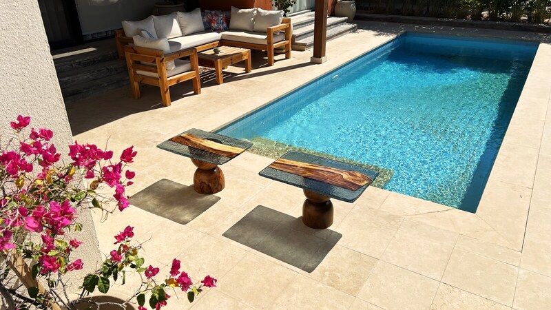 Resin tables — a pair of Strata pedestal tables by the pool
